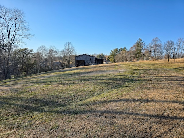 view of yard with a rural view and an outdoor structure