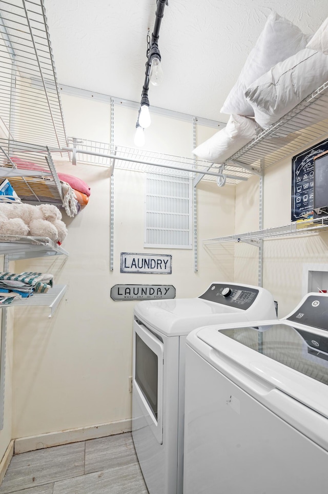 laundry room featuring light hardwood / wood-style floors and washing machine and dryer