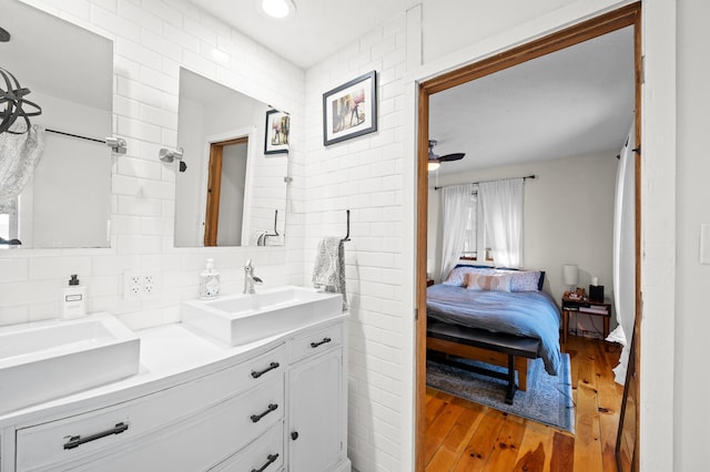 bathroom with vanity, hardwood / wood-style floors, and backsplash