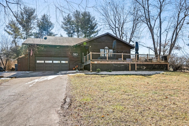 view of front of property with a wooden deck, a garage, and a front yard