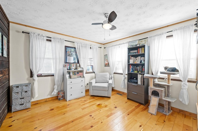 office space with crown molding, ceiling fan, light hardwood / wood-style flooring, and a textured ceiling