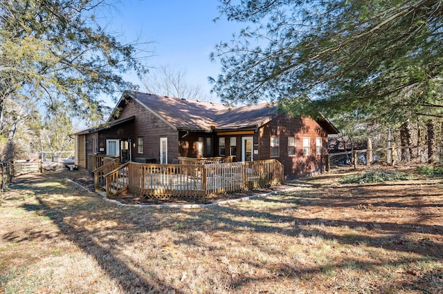 exterior space with a wooden deck and a front lawn