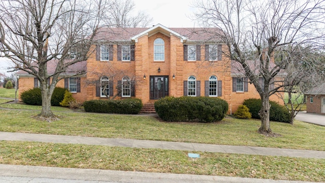 colonial-style house featuring a front lawn