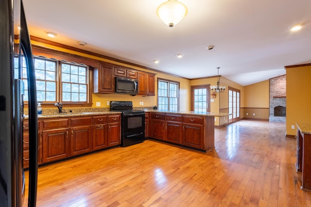 kitchen featuring decorative light fixtures, lofted ceiling, kitchen peninsula, crown molding, and black / electric stove