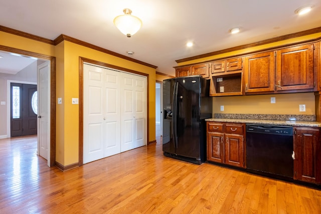 kitchen featuring ornamental molding, light stone countertops, light hardwood / wood-style flooring, and black appliances