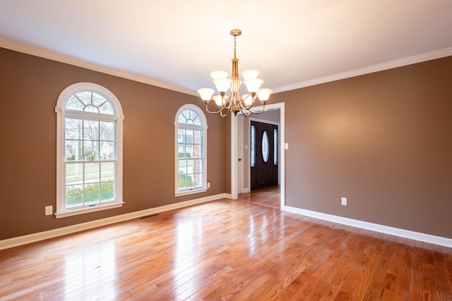 unfurnished room featuring ornamental molding, a chandelier, and light hardwood / wood-style flooring