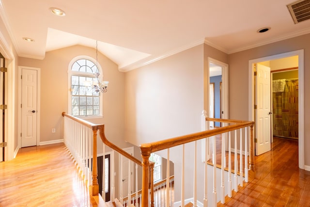 hall featuring crown molding, lofted ceiling, a chandelier, and hardwood / wood-style floors