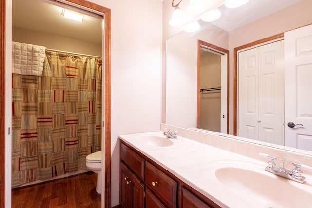 bathroom featuring wood-type flooring, vanity, and toilet