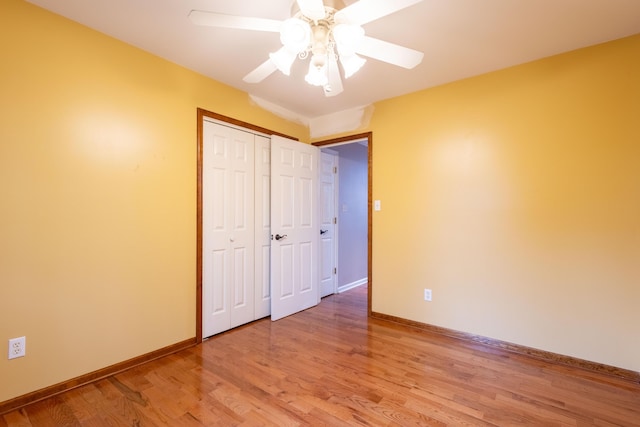 unfurnished bedroom featuring hardwood / wood-style flooring, ceiling fan, and a closet