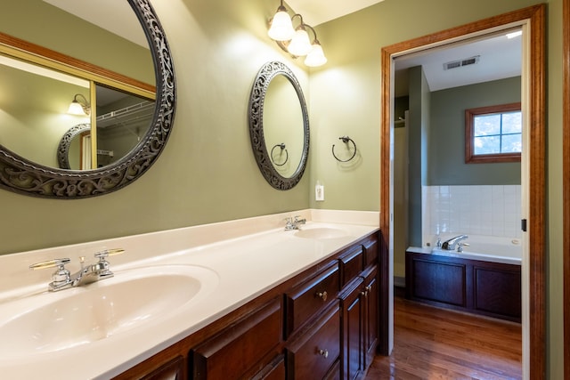 bathroom with vanity, hardwood / wood-style floors, and a tub