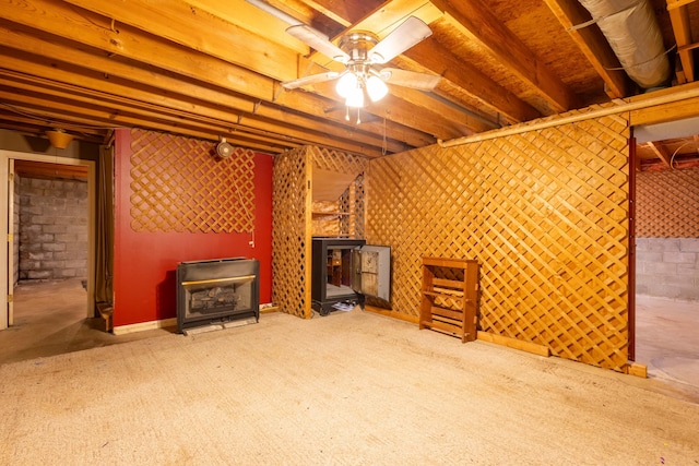 unfurnished living room featuring carpet, ceiling fan, and a wood stove