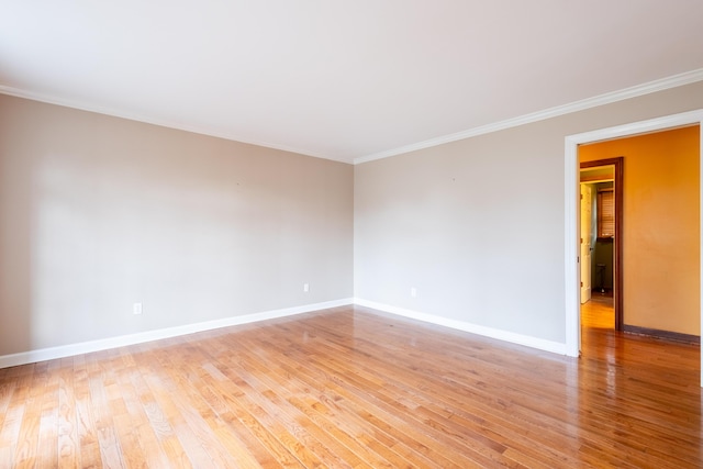 empty room featuring ornamental molding and light wood-type flooring