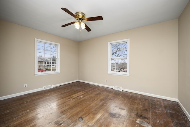 spare room featuring ceiling fan, a healthy amount of sunlight, and dark hardwood / wood-style flooring