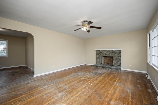 unfurnished living room with dark hardwood / wood-style flooring, a fireplace, and ceiling fan