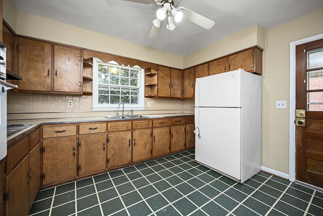 kitchen featuring sink, ceiling fan, decorative backsplash, cooktop, and white fridge