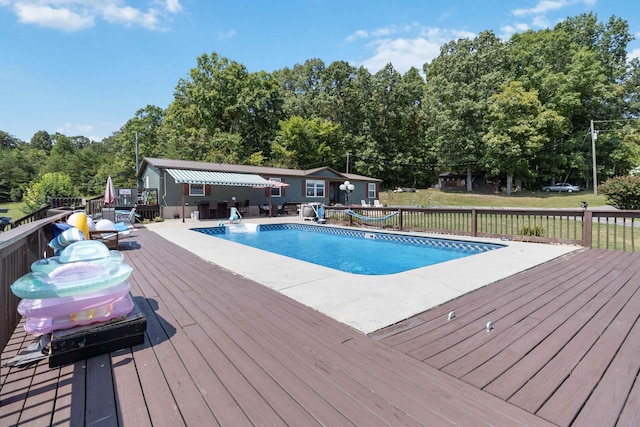 view of swimming pool featuring a wooden deck and an outdoor structure