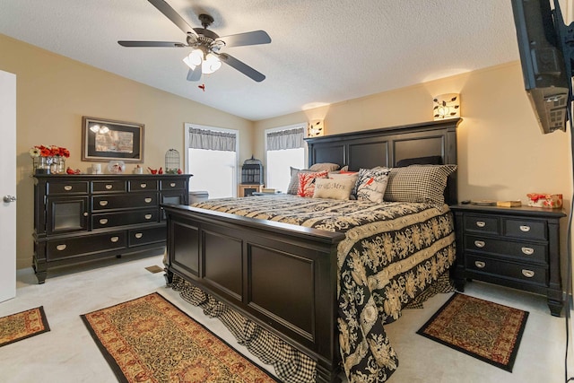 bedroom featuring vaulted ceiling, light carpet, ceiling fan, and a textured ceiling