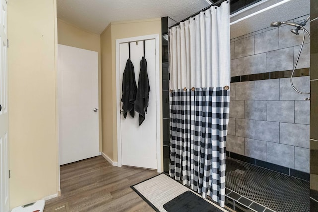 bathroom with hardwood / wood-style floors and tiled shower