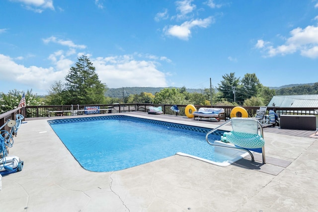 view of swimming pool with a mountain view and a patio area