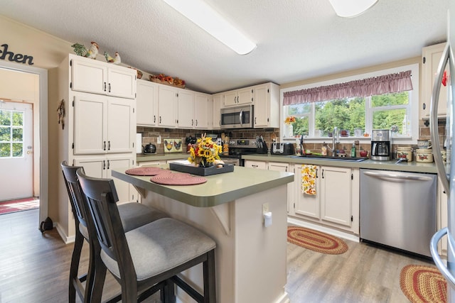 kitchen with white cabinetry, sink, a kitchen island, and appliances with stainless steel finishes