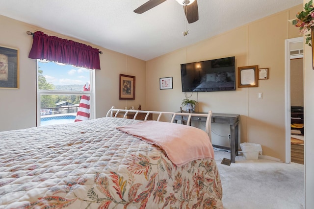 bedroom featuring ceiling fan, lofted ceiling, carpet, and a textured ceiling