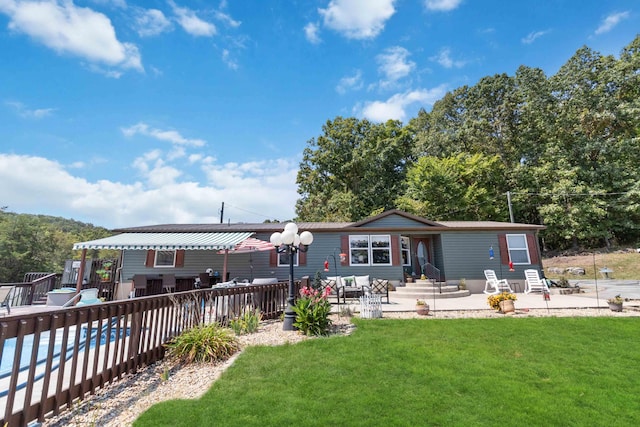 rear view of property with a yard and a patio area