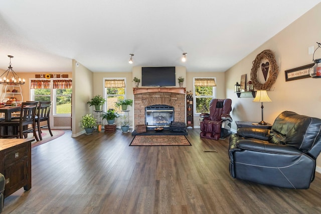 living room featuring plenty of natural light, a chandelier, and dark hardwood / wood-style flooring