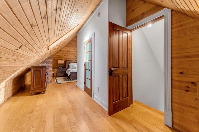 bonus room featuring lofted ceiling, wooden walls, wooden ceiling, and light hardwood / wood-style floors