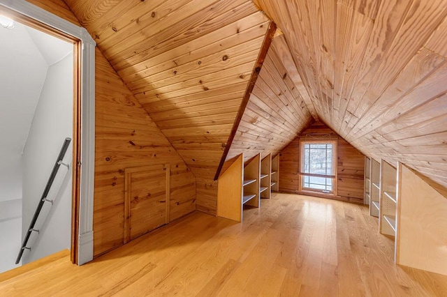 bonus room featuring lofted ceiling, wooden walls, light hardwood / wood-style floors, and wooden ceiling