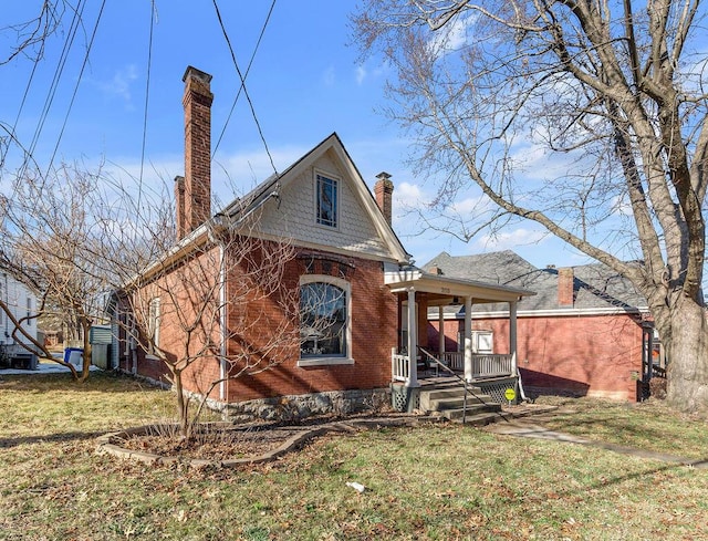 rear view of property with a lawn and a porch