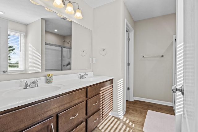 bathroom with a shower with door, vanity, and hardwood / wood-style floors