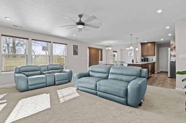 living room featuring light carpet and ceiling fan