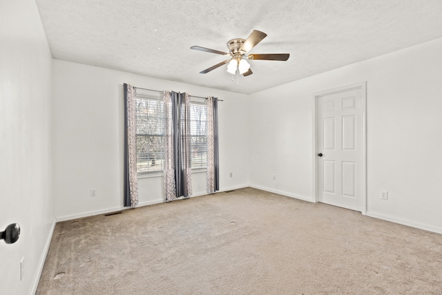 carpeted spare room with a textured ceiling and ceiling fan