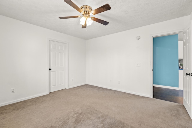 empty room featuring ceiling fan, carpet, and a textured ceiling