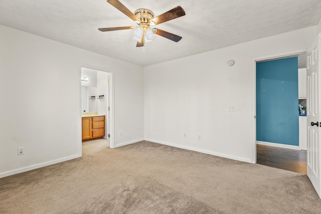 interior space featuring ceiling fan, connected bathroom, light carpet, and a textured ceiling