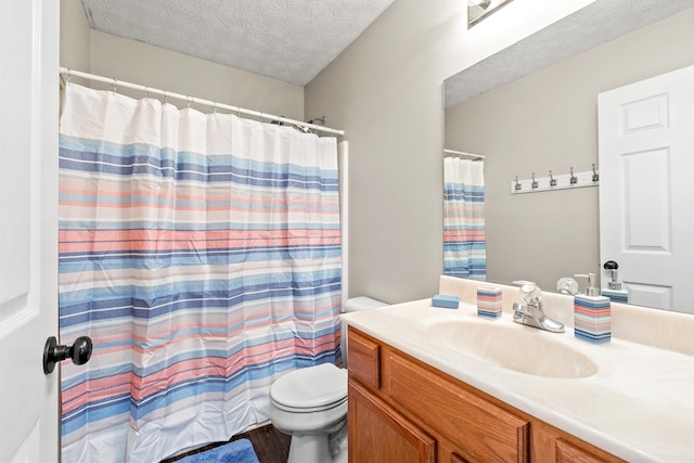 bathroom with vanity, walk in shower, a textured ceiling, and toilet