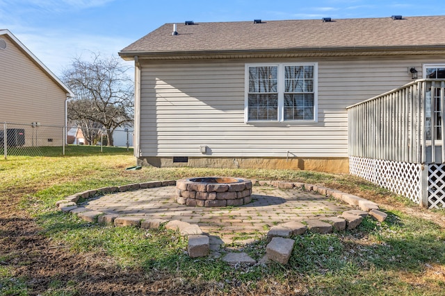 rear view of property with a yard and an outdoor fire pit