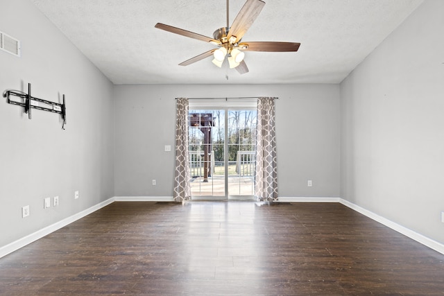 spare room with dark wood-type flooring, ceiling fan, and a textured ceiling