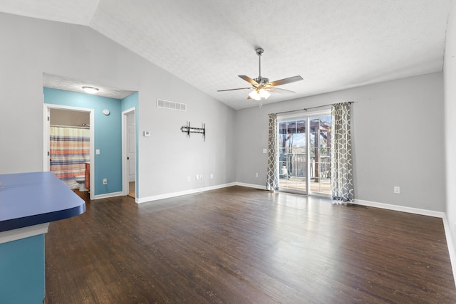 unfurnished living room with a textured ceiling, vaulted ceiling, dark hardwood / wood-style floors, and ceiling fan