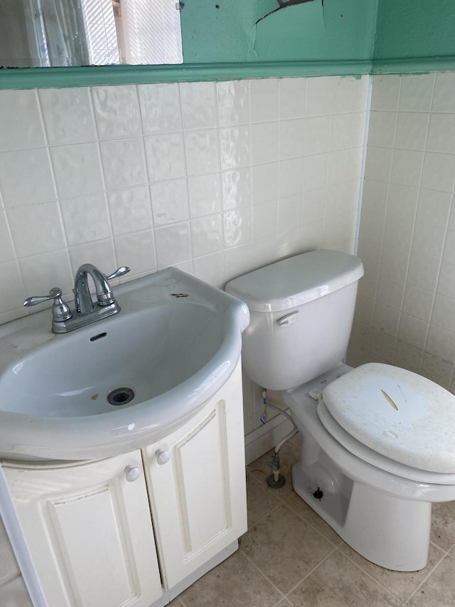 bathroom with vanity, tile walls, tile patterned floors, and toilet