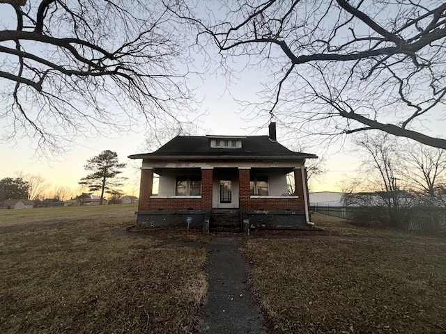 bungalow-style home with a yard and a porch