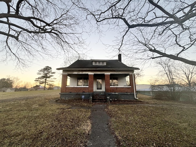 bungalow-style house featuring a porch and a lawn