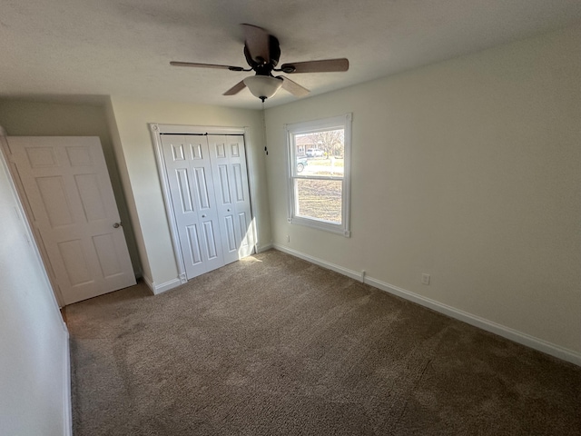 unfurnished bedroom featuring carpet floors, ceiling fan, and a closet