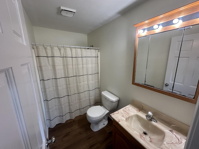 bathroom featuring toilet, a shower with curtain, a textured ceiling, vanity, and hardwood / wood-style floors