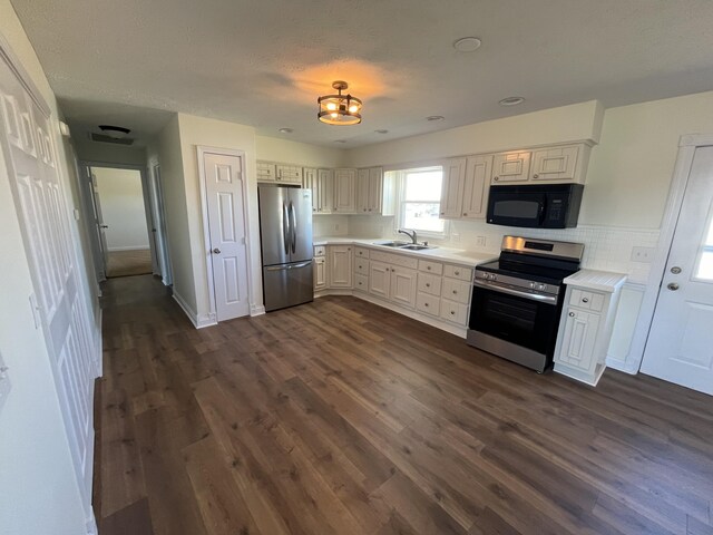 kitchen featuring stainless steel appliances, white cabinetry, sink, and dark hardwood / wood-style flooring