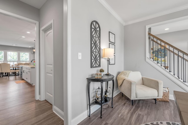 living area with hardwood / wood-style floors and ornamental molding