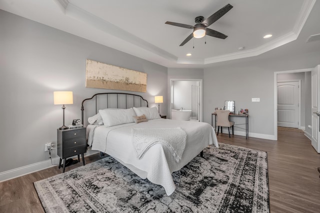 bedroom with dark hardwood / wood-style flooring, a tray ceiling, and ornamental molding