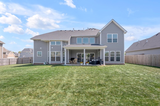 back of house featuring a patio area and a lawn