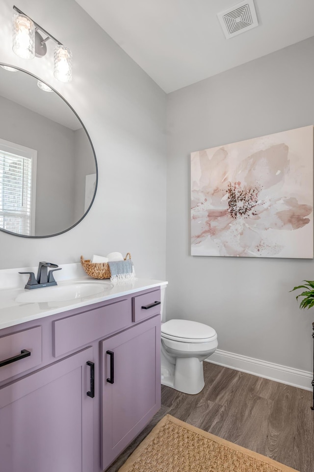 bathroom with hardwood / wood-style flooring, vanity, and toilet