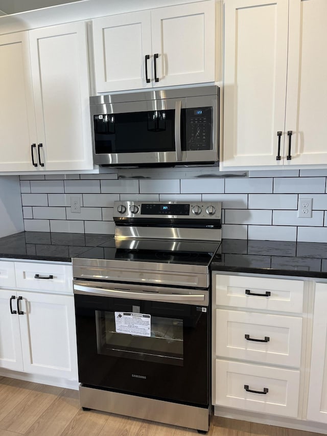 kitchen featuring tasteful backsplash, appliances with stainless steel finishes, and white cabinetry